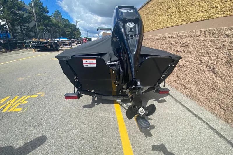 Slide: The Image of 2023 Crestliner 1650 Discovery SC boat with outboard motor, parked on a street. - 4