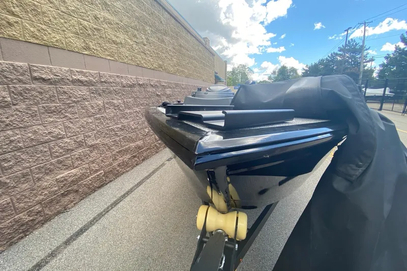 Slide: The Image of 2023 Crestliner 1650 Discovery SC boat, black hull, parked outdoors under a blue sky. - 5