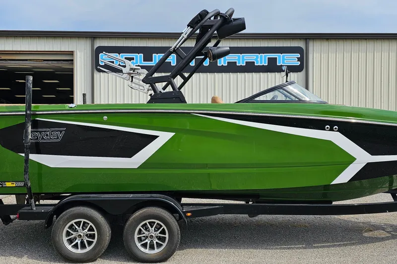 Slide: The Image of 2025 Heyday WTSurf boat in vibrant green, parked outside Aqua Marine facility. - 0
