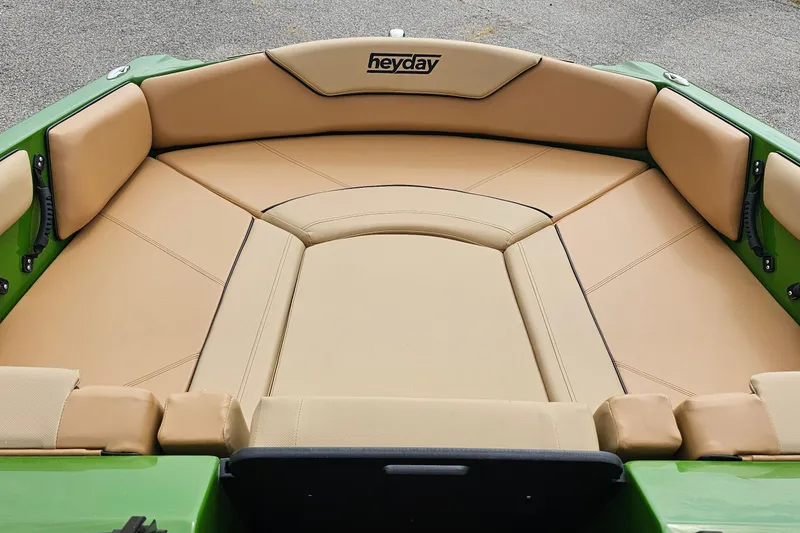 Slide: The Image of 2025 Heyday WTSurf boat interior with tan seating and green accents. - 4