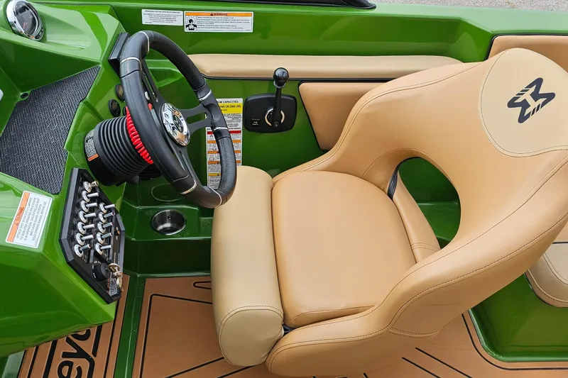Slide: The Image of 2025 Heyday WTSurf boat interior with green dashboard and tan captain's chair. - 7