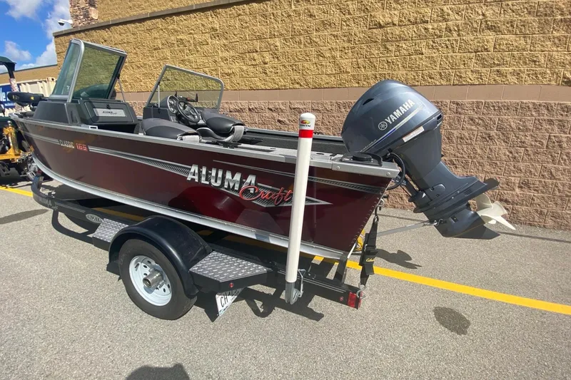 Slide: The Image of 2017 Alumacraft Classic 165 boat with Yamaha motor on trailer, parked outdoors. - 3
