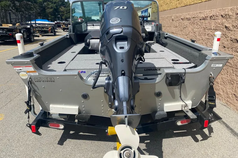 Slide: The Image of 2017 Alumacraft Classic 165 boat with outboard motor, parked on a trailer. - 4