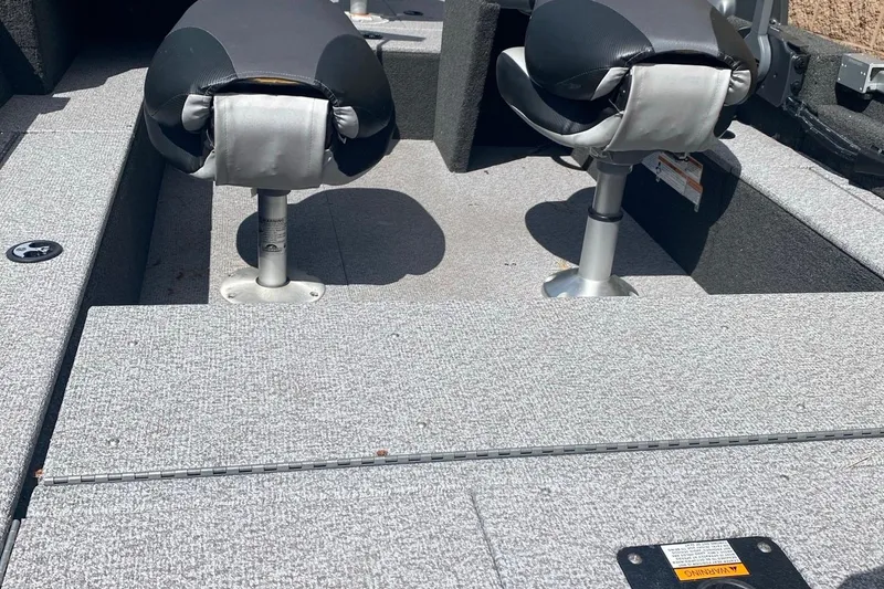 Slide: The Image of 2017 Alumacraft Classic 165 boat interior with two swivel seats and carpeted flooring. - 8