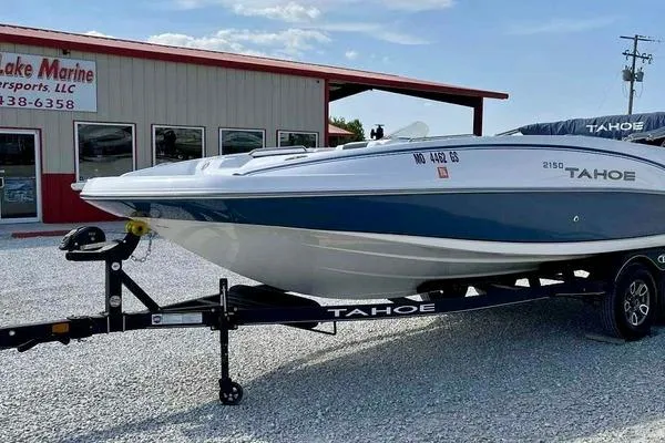 Slide: The Image of 2023 Tahoe 2150 boat on trailer outside dealership, sunny day. - 1