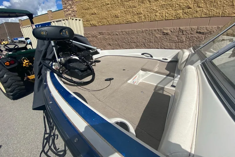 Slide: The Image of 2014 Nitro Z7 Sport boat interior with seating and equipment, parked near a tractor. - 6