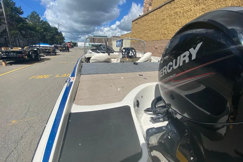 Slide: The Image of 2014 Nitro Z7 Sport boat with Mercury engine, parked outdoors under a cloudy sky. - 8