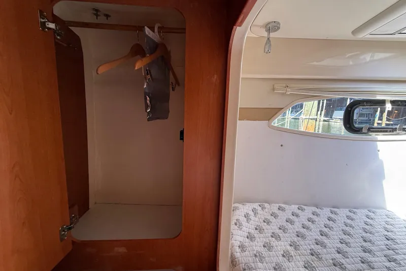 Slide: The Image of Leopard 38 (2010) yacht interior with open closet and bed, featuring a window view. - 101