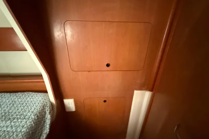 Slide: The Image of Wooden interior of a 2010 Leopard 38 yacht, featuring storage compartments and a bed. - 103