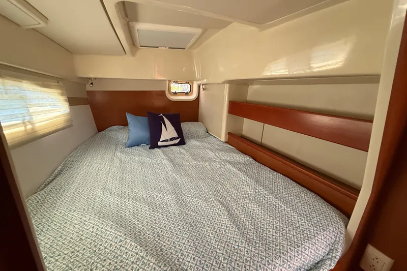 Slide: The Image of Cozy cabin interior of 2010 Leopard 38 catamaran with bed and nautical-themed pillows. - 104