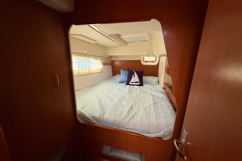 Slide: The Image of Cozy cabin interior of 2010 Leopard 38 catamaran with bed and nautical-themed pillows. - 105