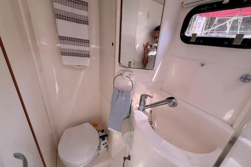 Slide: The Image of Compact bathroom in a 2010 Leopard 38 yacht, featuring a sink, toilet, and mirror. - 106