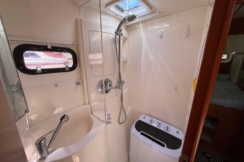 Slide: The Image of Compact bathroom in a 2010 Leopard 38 yacht with shower and washing machine. - 107
