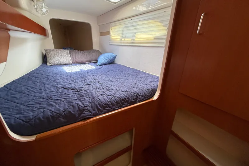 Slide: The Image of Cozy cabin interior of 2010 Leopard 38 yacht with blue bedding and wooden accents. - 109
