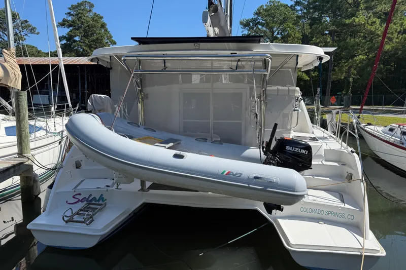 Slide: The Image of 2010 Leopard 38 catamaran with dinghy and Suzuki outboard motor docked in marina. - 11