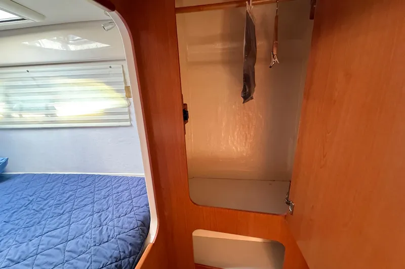 Slide: The Image of Interior of 2010 Leopard 38 yacht showing bedroom and wooden closet space. - 117