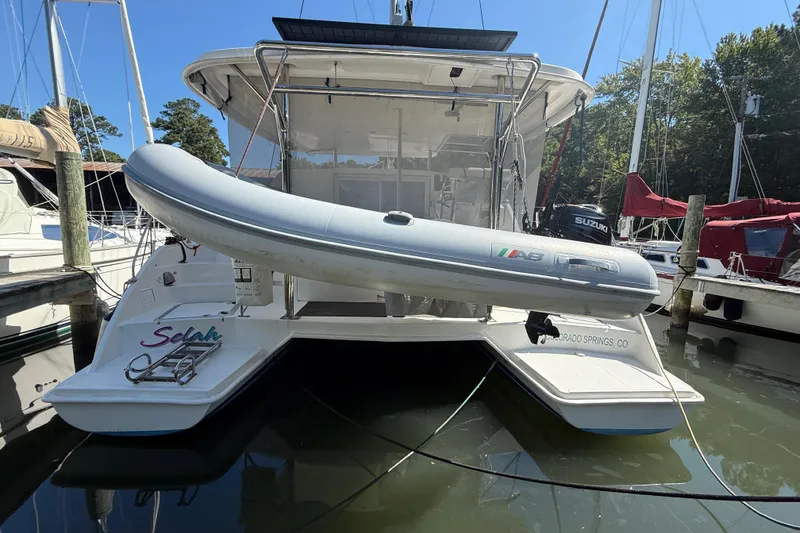 Slide: The Image of 2010 Leopard 38 catamaran with dinghy, docked in a marina, sunny day. - 13