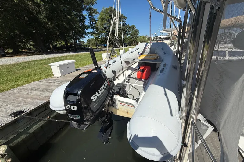 Slide: The Image of Inflatable boat with Suzuki 20HP motor on Leopard 38, 2010 model, docked by a wooden pier. - 15