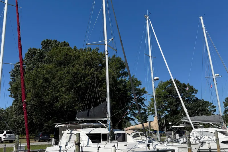 Slide: The Image of Sailboats docked at a marina, featuring a 2010 Leopard 38 catamaran under a clear blue sky. - 3