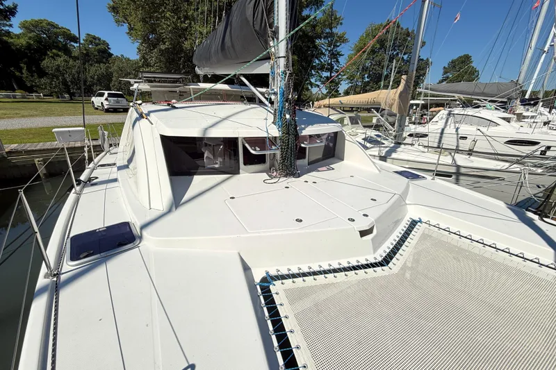 Slide: The Image of 2010 Leopard 38 catamaran docked, showcasing deck and rigging under clear blue sky. - 32