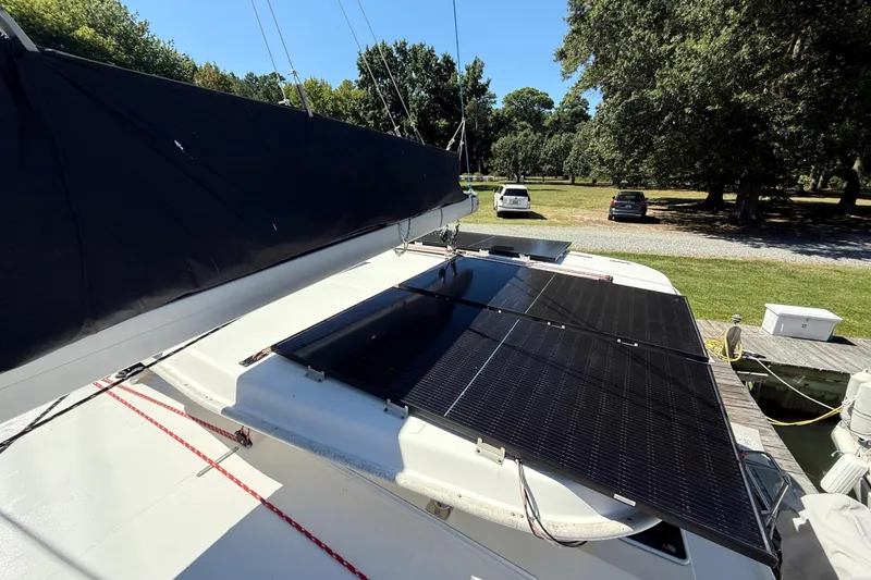 Slide: The Image of 2010 Leopard 38 catamaran with solar panels on deck, docked near a grassy area. - 43