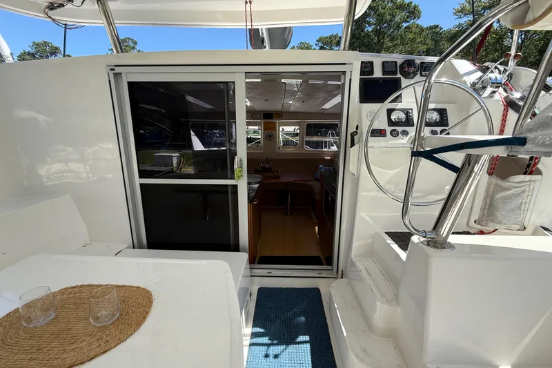 Slide: The Image of Leopard 38 catamaran cockpit with steering wheel, sliding door, and outdoor seating area. - 50