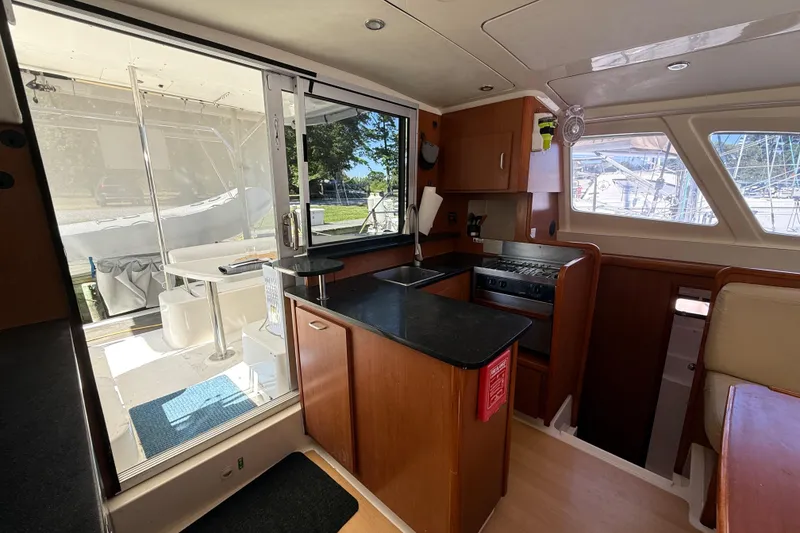Slide: The Image of Interior of 2010 Leopard 38 catamaran featuring kitchen and outdoor seating area. - 60