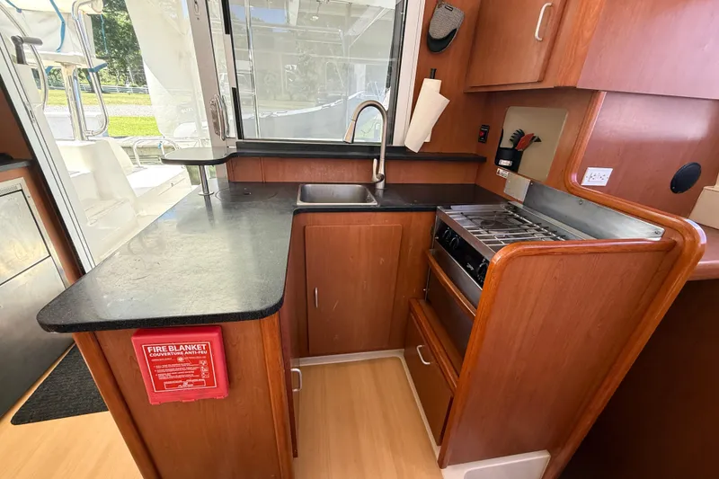 Slide: The Image of Compact kitchen in a 2010 Leopard 38 yacht with wooden cabinetry and modern appliances. - 62