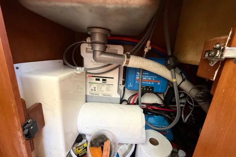 Slide: The Image of Under-sink storage in 2010 Leopard 38 yacht with plumbing and electrical components. - 64