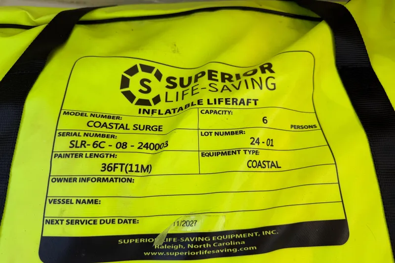 Slide: The Image of Yellow inflatable liferaft label, model Coastal Surge, capacity 6, next service due 11/2027. - 71