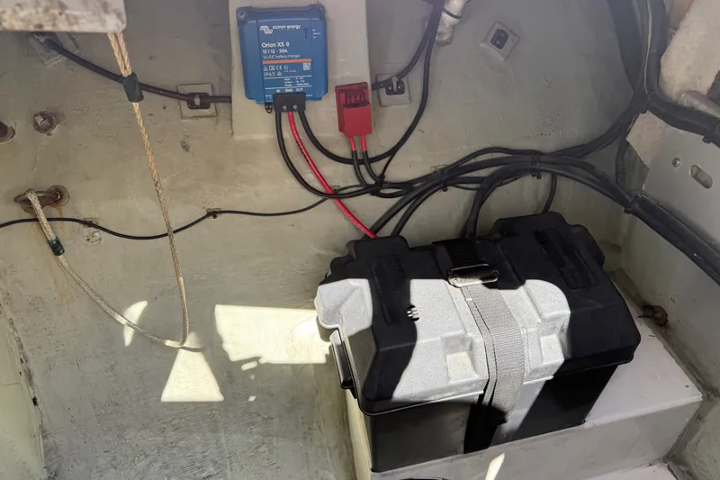 Slide: The Image of Battery compartment of a 2010 Leopard 38 with wiring and charger. - 73