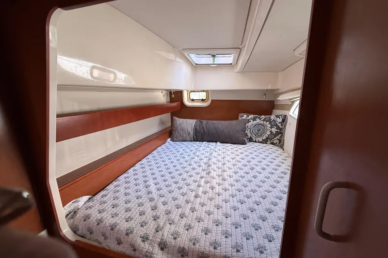 Slide: The Image of Cozy cabin interior of 2010 Leopard 38 yacht with patterned bedding and wooden accents. - 92