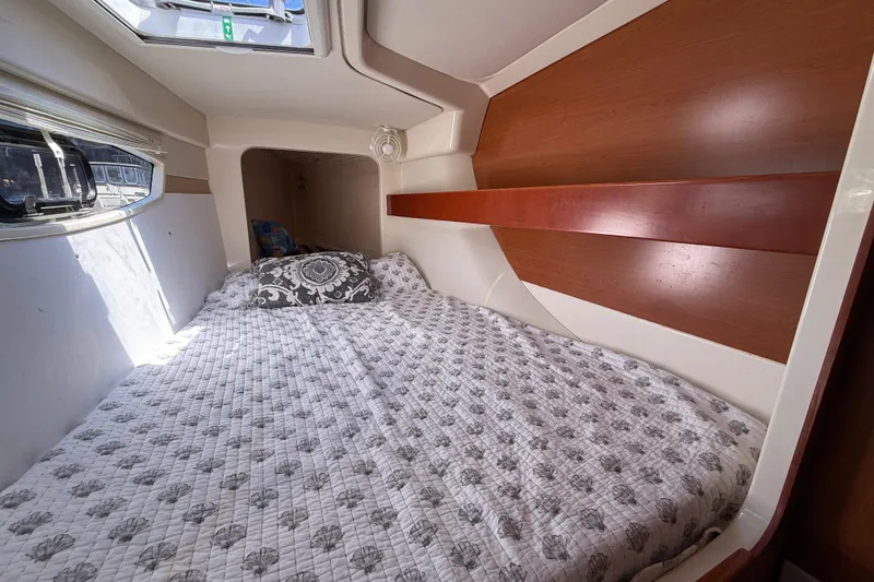 Slide: The Image of Cozy cabin interior of 2010 Leopard 38 yacht with patterned bedding and window view. - 97