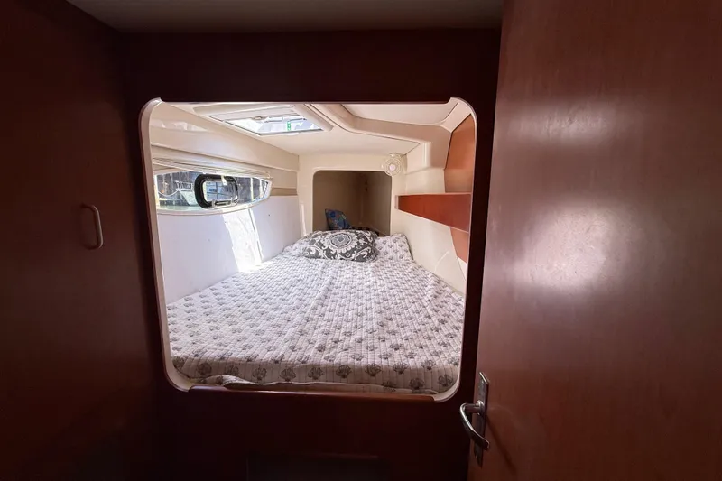 Slide: The Image of Cozy bedroom interior of 2010 Leopard 38 yacht with window and patterned bedding. - 99