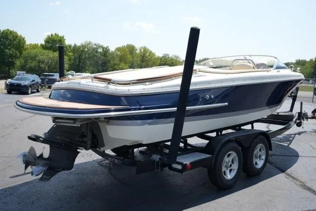 Slide: The Image of 2015 Chris-Craft Capri 21 boat on trailer, parked outdoors. - 3