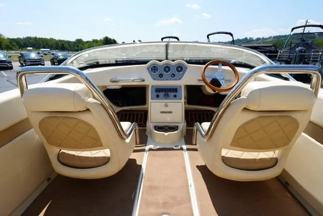 Slide: The Image of 2015 Chris-Craft Capri 21 boat interior with elegant beige seating and classic wooden steering wheel. - 7