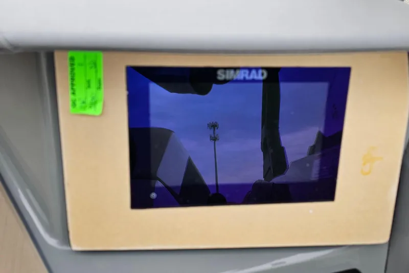 Slide: The Image of Simrad display on 2025 Heyday H20 boat dashboard, reflecting sky and surroundings. - 9