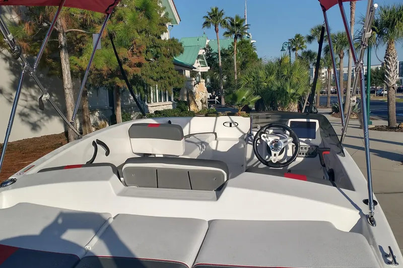 Slide: The Image of 2026 Tahoe T16 boat interior with modern steering and seating, surrounded by palm trees. - 3