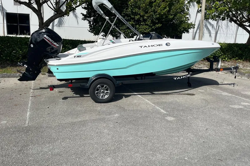 Slide: The Image of 2026 Tahoe T16 boat on trailer, parked outdoors, featuring a sleek design and outboard motor. - 1