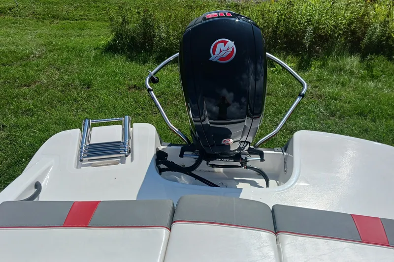 Slide: The Image of 2026 Tahoe T18 boat with Mercury outboard motor and swim ladder on grassy background. - 10