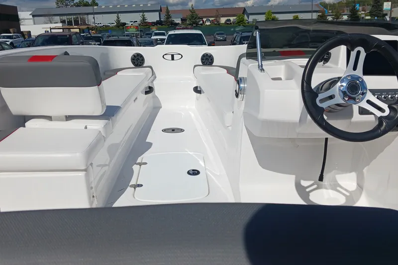 Slide: The Image of 2026 Tahoe T18 boat interior with steering wheel and seating, parked outdoors. - 5