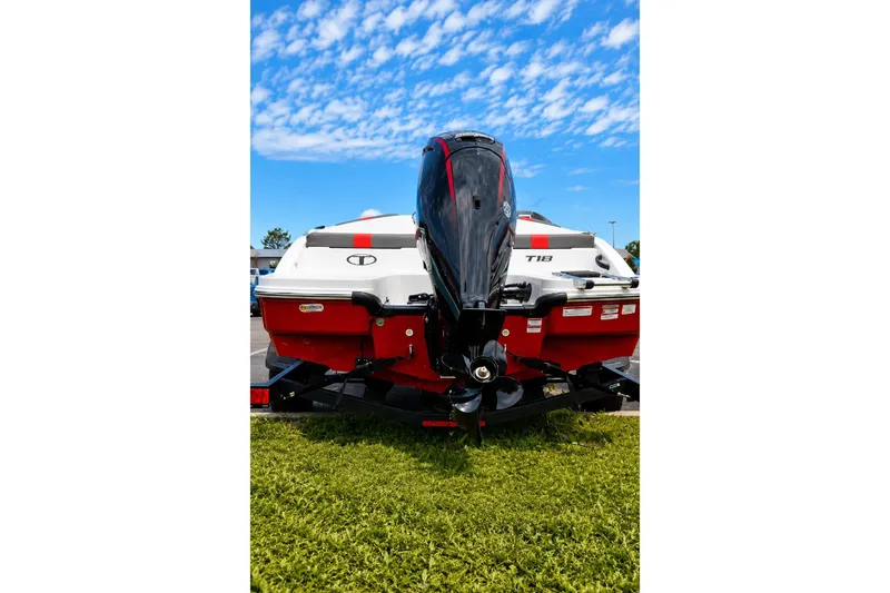 Slide: The Image of 2026 Tahoe T18 boat with outboard motor, parked on grass under blue sky. - 3