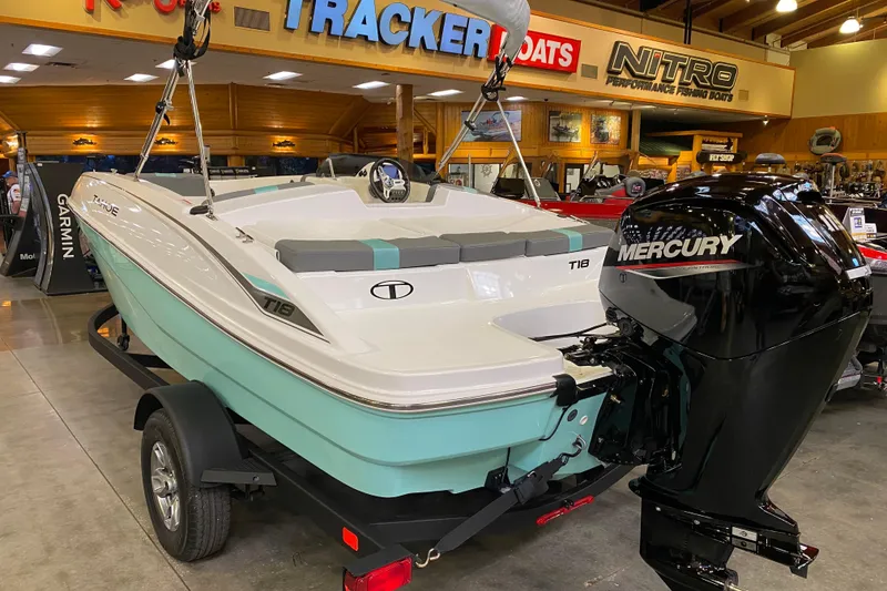 Slide: The Image of 2026 Tahoe T18 boat with Mercury engine displayed indoors. - 2
