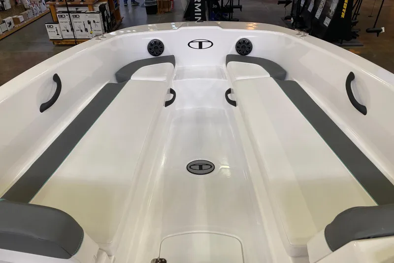 Slide: The Image of 2026 Tahoe T18 boat interior with gray seating and speakers, displayed in a showroom. - 5