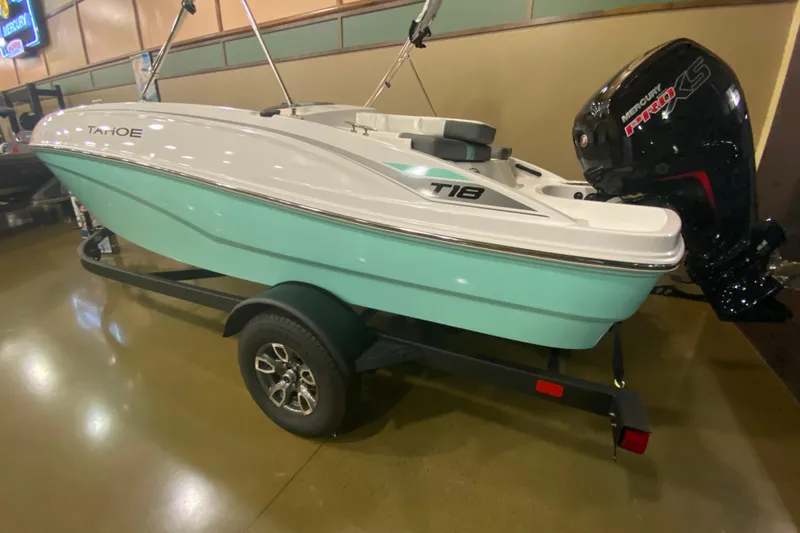 Slide: The Image of 2026 Tahoe T18 boat with outboard motor on a trailer in showroom. - 1