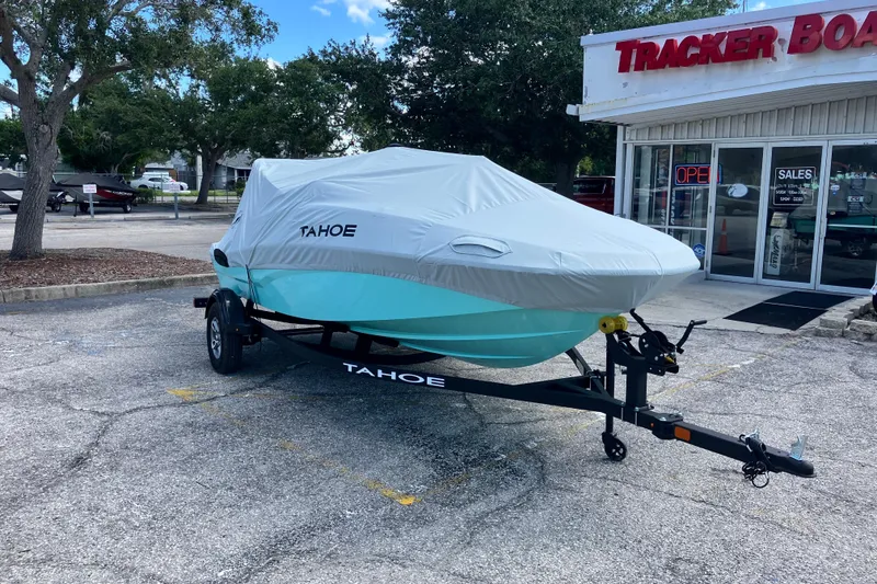 Slide: The Image of 2026 Tahoe T16 boat covered on trailer outside dealership. - 67
