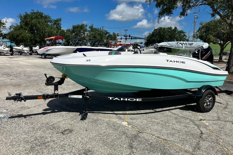 Slide: The Image of 2026 Tahoe T16 boat on trailer in outdoor lot, under clear blue sky. - 70