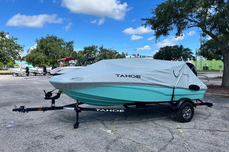 Slide: The Image of 2026 Tahoe T16 boat with cover on trailer in parking lot, under blue sky. - 71