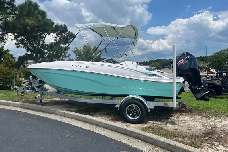 Slide: The Image of 2026 Tahoe T18 boat on trailer, parked outdoors under cloudy sky. - 1