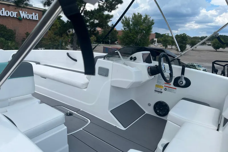 Slide: The Image of 2026 Tahoe T18 boat interior with steering wheel, seating, and dashboard, parked near Outdoor World. - 5